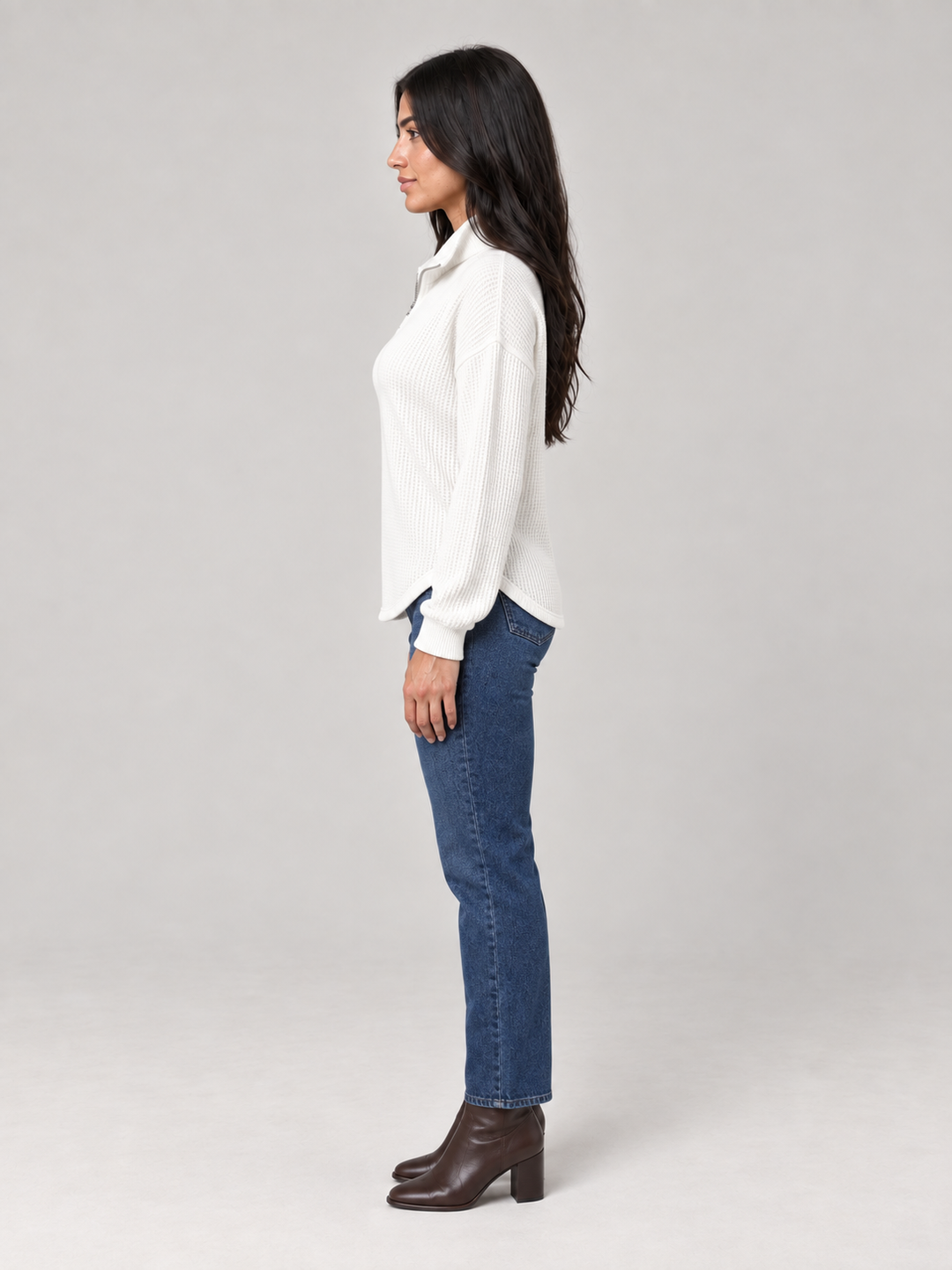 Weißer Damen-Troyer im Waffelstrick mit Stehkragen und Reißverschluss in lockerer Passform zu blauer Jeans.