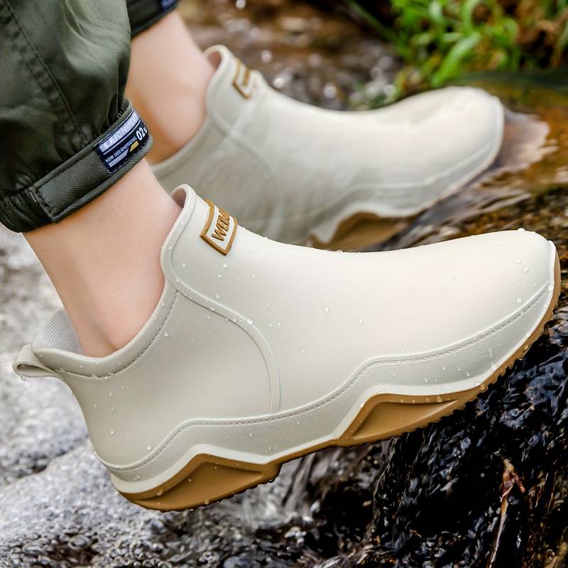 Beigefarbene, wasserdichte Damen-Stiefeletten zum Hineinschlüpfen mit rutschfester, brauner Profilsohle bei Nässe.