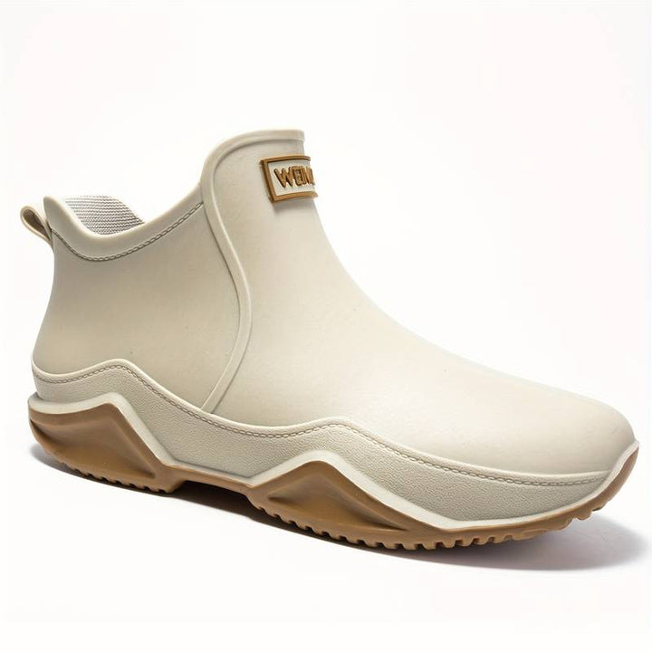 Beigefarbene, wasserdichte Damen-Stiefelette zum Hineinschlüpfen mit brauner Profilsohle und knöchelhohem Schaft.