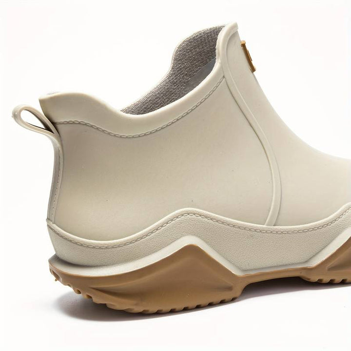 Beigefarbene, wasserdichte Damen-Stiefelette zum Schlüpfen mit markanter, brauner Wellen-Laufsohle und Anziehschlaufe.