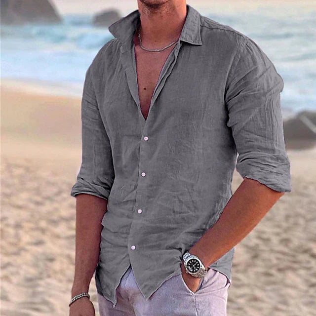 Graues Herren-Langarmhemd aus leichtem Leinen-Baumwoll-Mix mit klassischem Kragen und Knopfleiste am Strand.