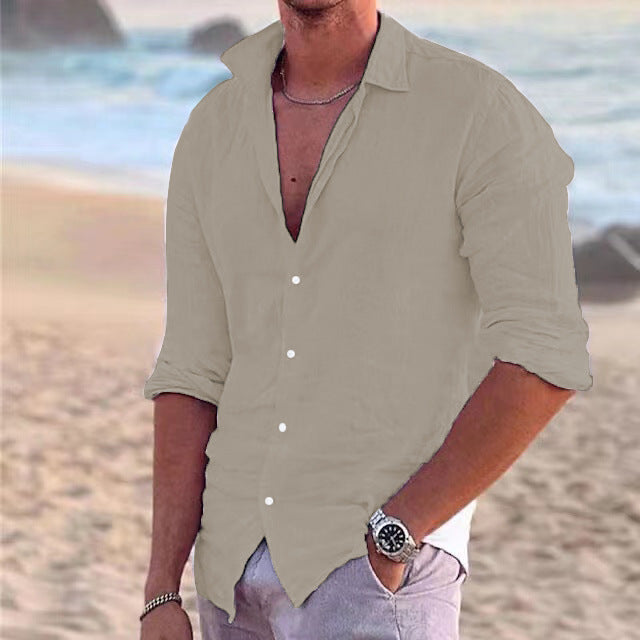 Beiges Herren-Langarmhemd aus leichtem Baumwoll-Leinen-Mix mit klassischem Kragen und Knopfleiste am Strand.