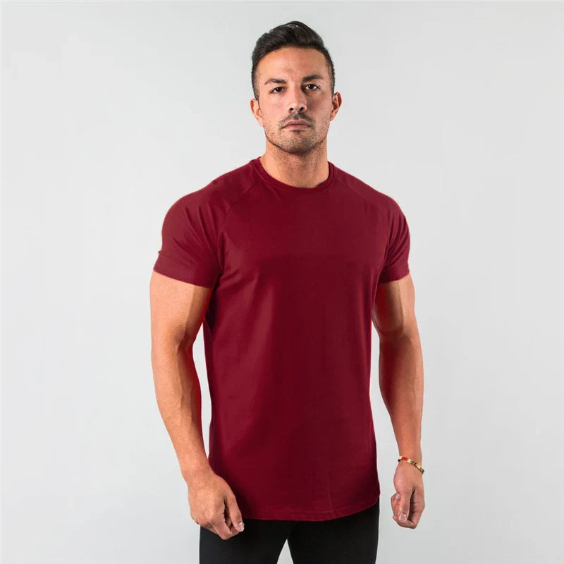 Dunkelrotes, figurbetontes Herren-T-Shirt mit kurzen Ärmeln und Rundhalsausschnitt vor neutralem Hintergrund.