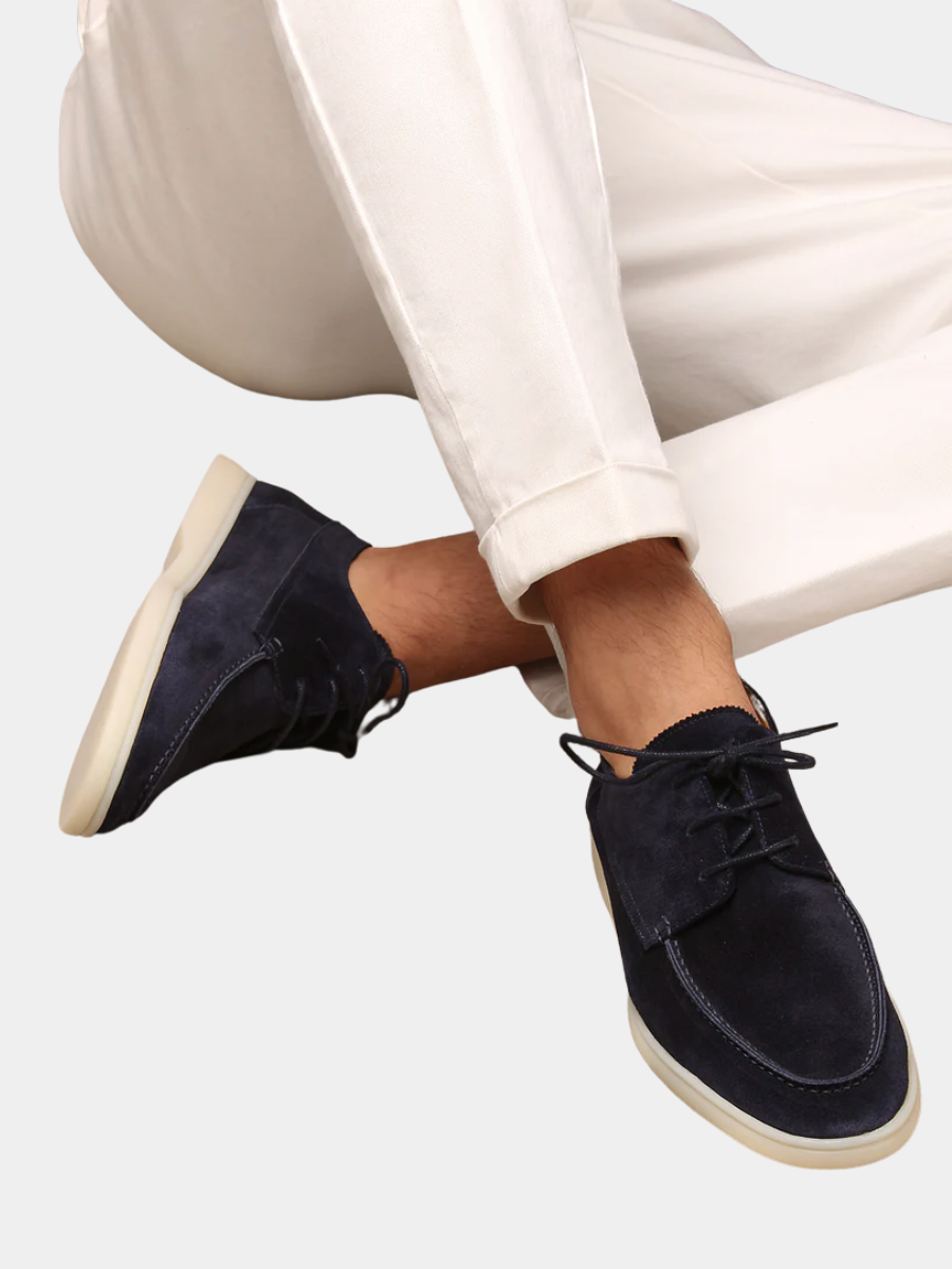 Dunkelblaue Herren-Schnürschuhe aus weichem Wildleder mit heller Sohle, kombiniert mit einer weißen Stoffhose.