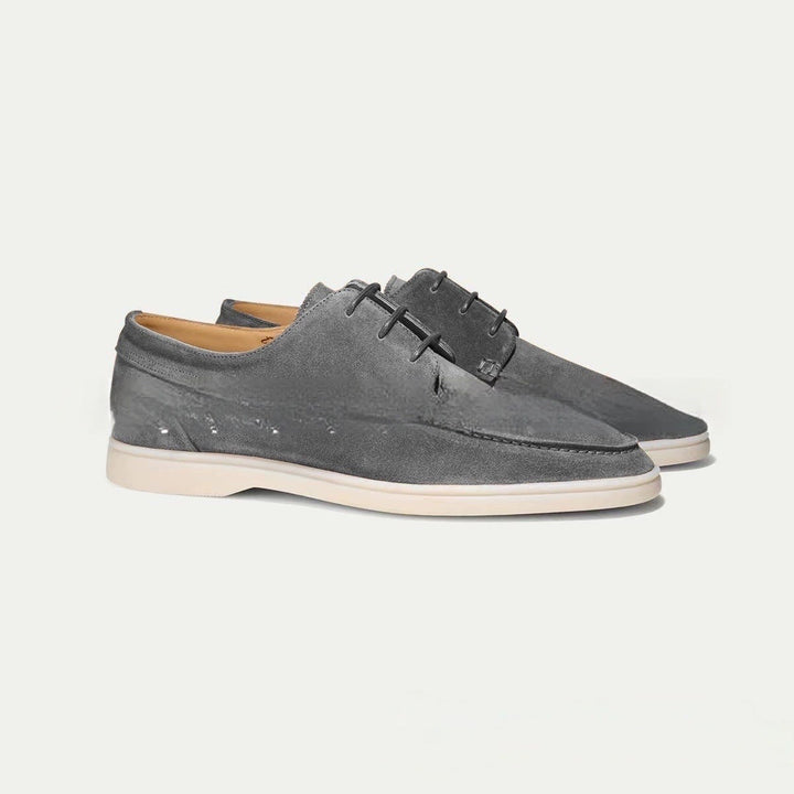 Graue Herren-Schnürschuhe aus weichem Wildleder mit heller, leichter Kontrastsohle und eleganter Silhouette.