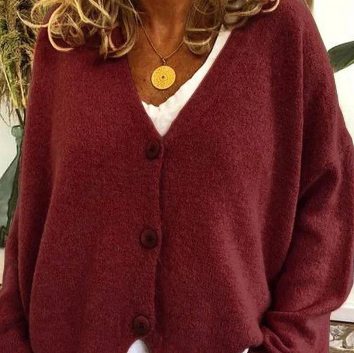 Dunkelrote Strickjacke Noemi mit V-Ausschnitt, Knopfleiste und weichem Material für einen femininen Look.