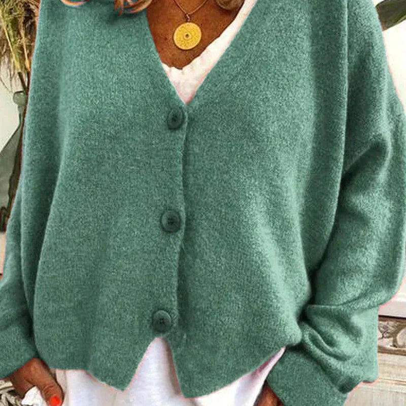 Grüne Strickjacke Noemi mit V-Ausschnitt, Knopfleiste und weichem Material für einen eleganten, femininen Look.