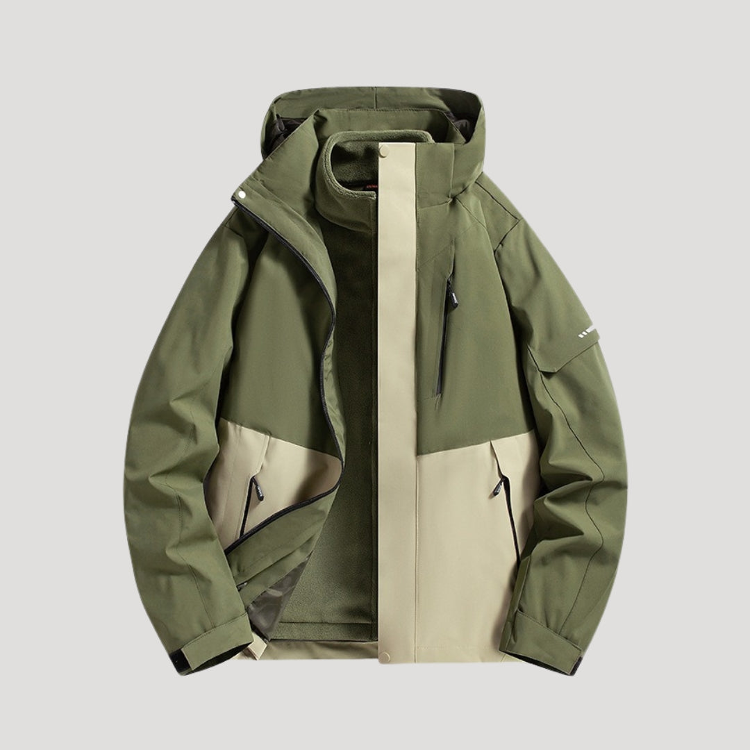 Olivgrüne und beige wasserdichte Damen Outdoorjacke mit Kapuze, Reißverschlusstaschen und sportlichem Design.
