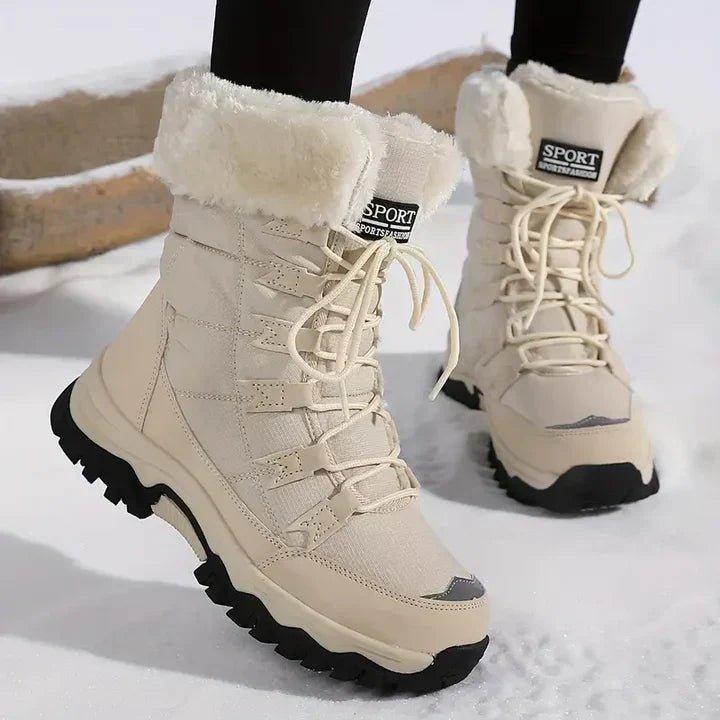 Beigefarbene, warm gefütterte Winter-Snowboots mit Kunstfellkragen, Schnürung und robuster, profilierter schwarzer Sohle.