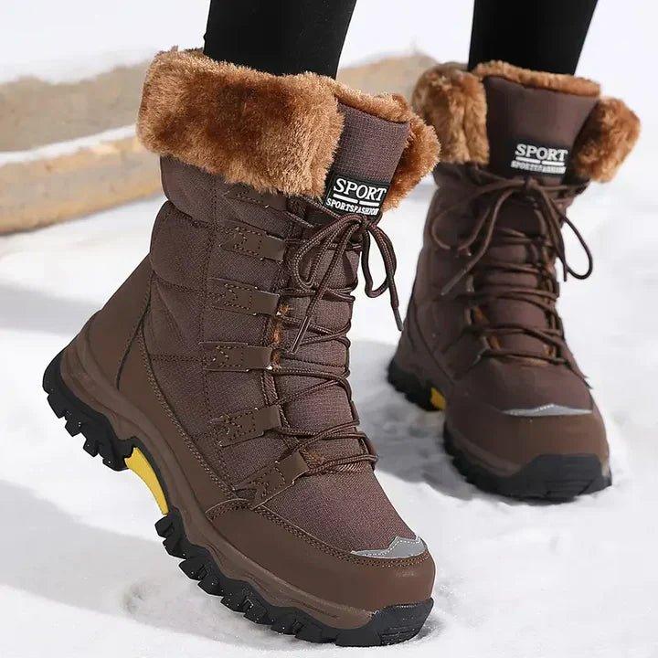 Braune, gefütterte Marika Winter-Snowboots mit Kunstfellkragen, Schnürung und profilierter Sohle im Schnee.