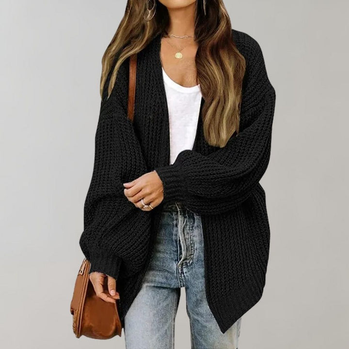 Schwarze Oversized-Strickjacke aus grobem Strick mit offener Vorderseite und weiten Ärmeln für einen lässigen Look.