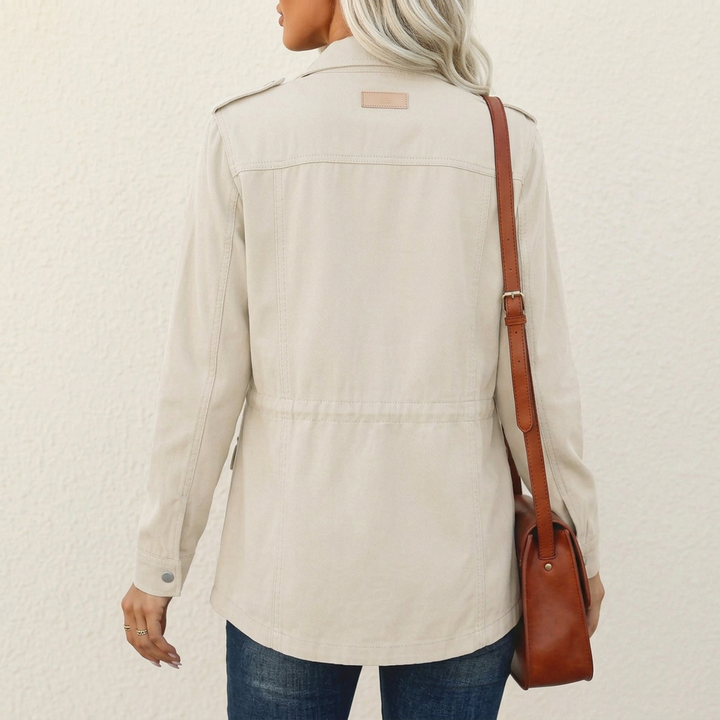 Beige Utility-Jacke für Damen mit Schulterlaschen, tailliertem Schnitt und Kordelzug in der Rückenansicht.
