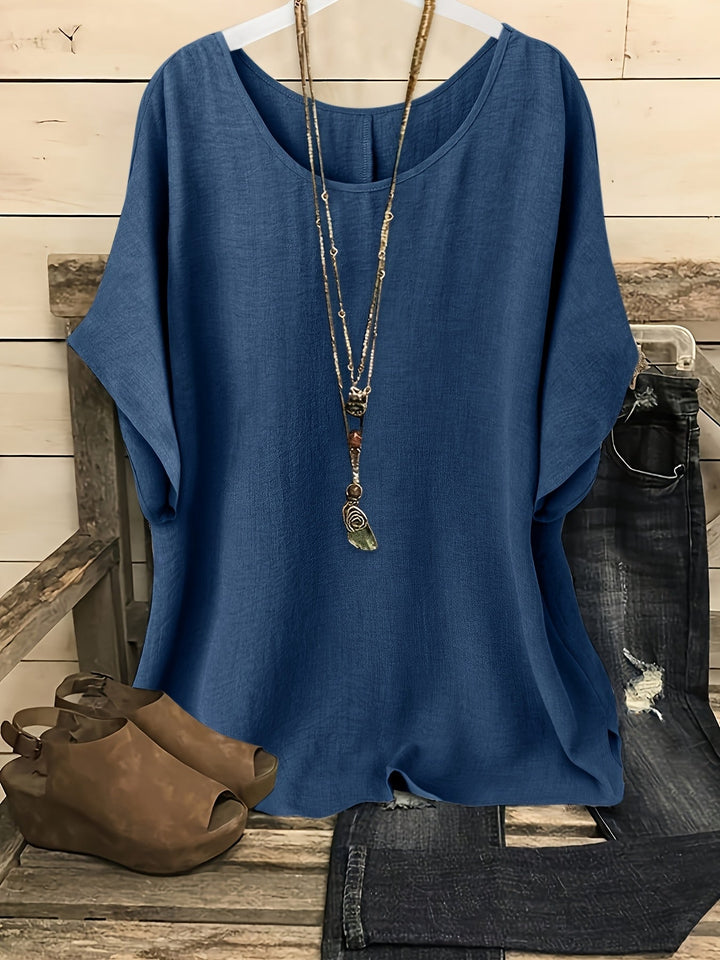 Dunkelblaues Damen-Shirt in Leinen-Optik mit Rundhals, kurzen Ärmeln und lockerer Passform, kombiniert mit Kette und Jeans.