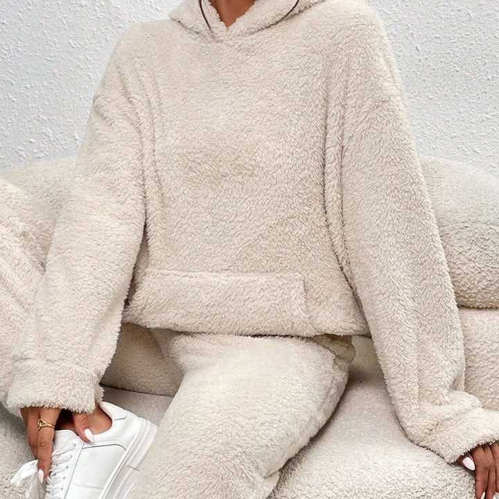 Beiger Damen Teddy-Zweiteiler mit kuscheligem Hoodie, Kapuze, Kängurutasche und bequemer Hose für gemütliche Tage.