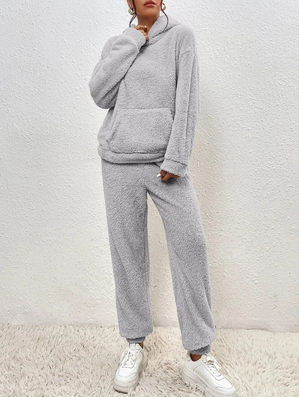Grauer Damen Teddy-Zweiteiler mit kuscheligem Kapuzen-Hoodie, Kängurutasche und bequemer Hose für gemütliche Tage.