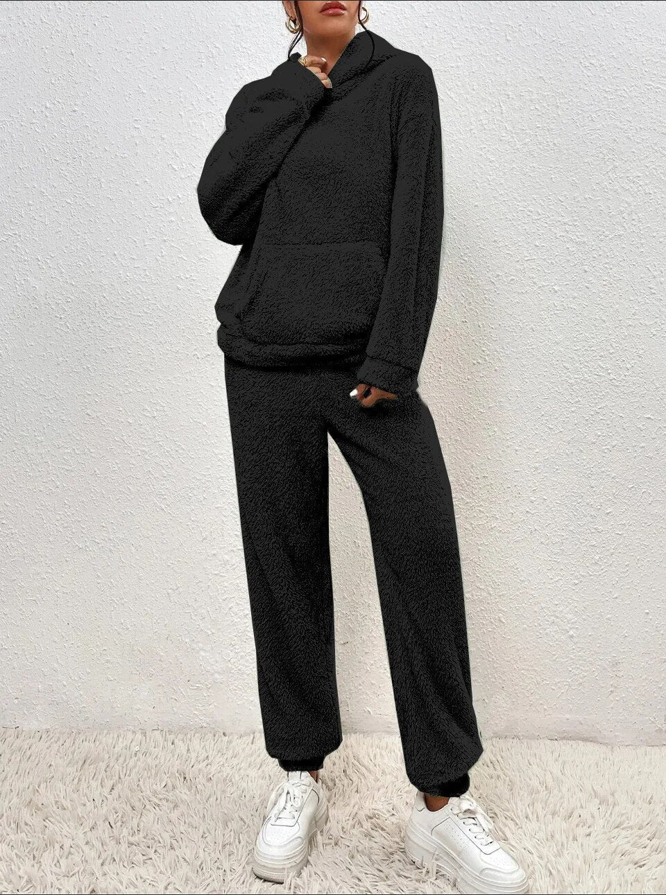 Schwarzer Damen Teddy-Zweiteiler mit kuscheligem Kapuzen-Hoodie und bequemer Hose für gemütliche Wintertage.