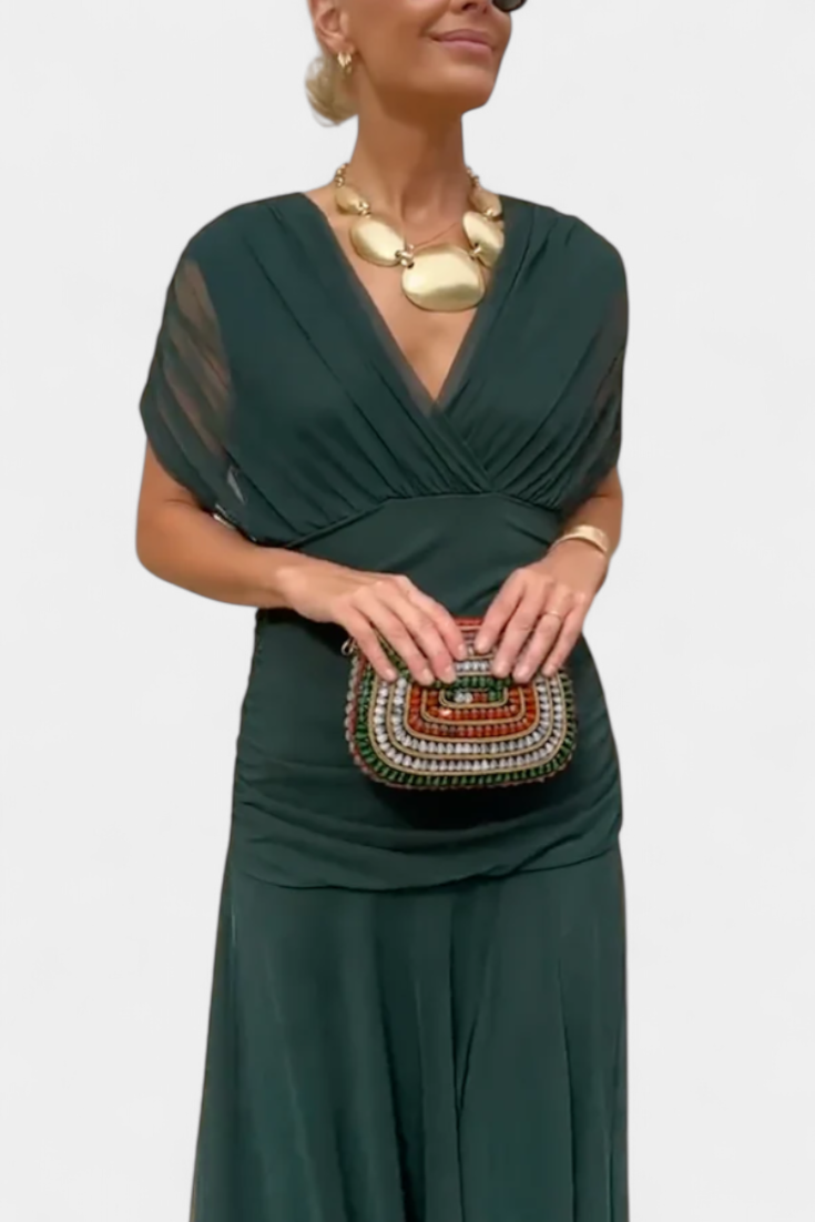 Dunkelgrünes Melina Maxikleid mit V-Ausschnitt, geraffter Taille und fließendem Stoff für einen eleganten Look.