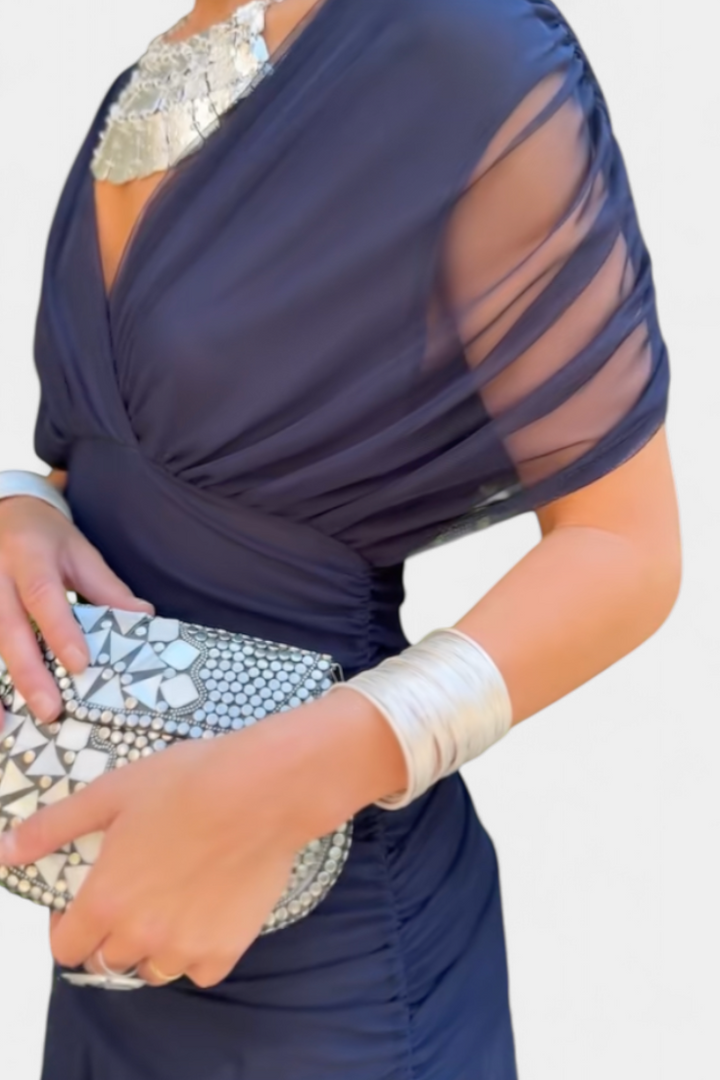 Dunkelblaues Melina Maxikleid mit V-Ausschnitt, geraffter Taille und drapierten Schultern aus fließendem Stoff.