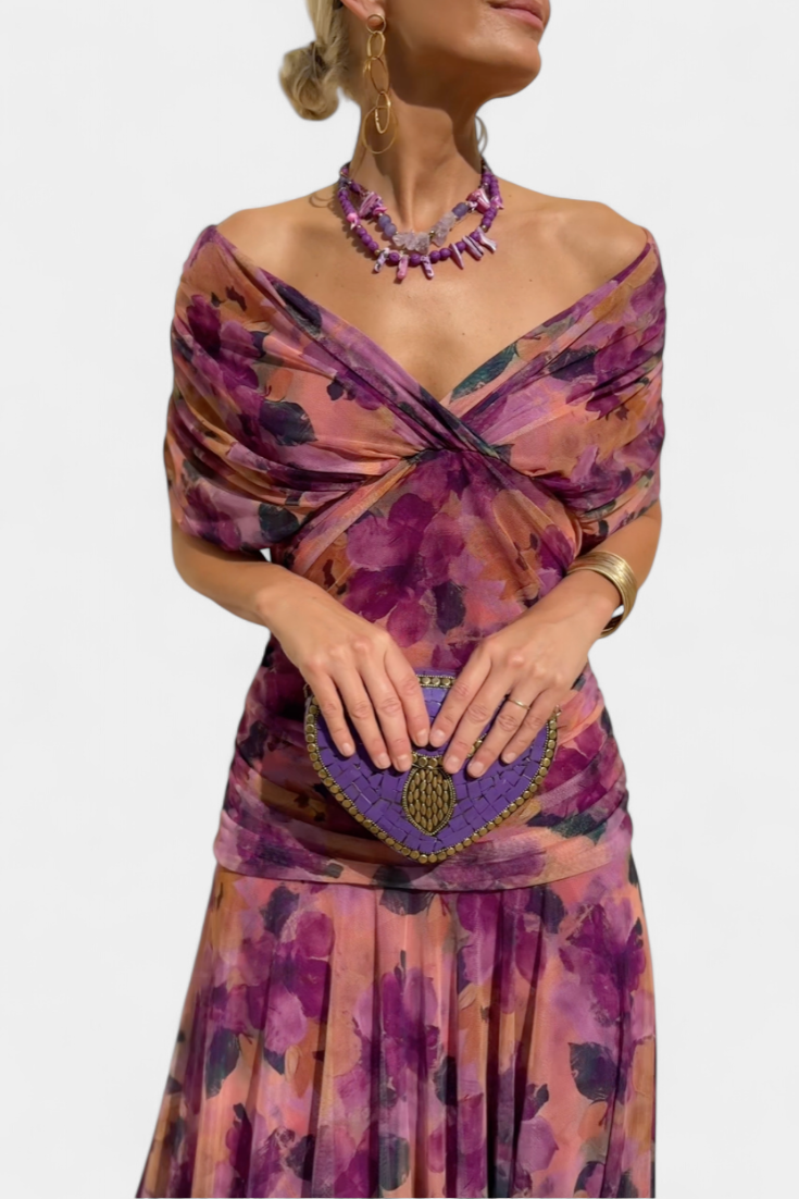 Lila Maxikleid mit floralem Muster, V-Ausschnitt, geraffter Taille und fließendem Stoff für einen eleganten Look.