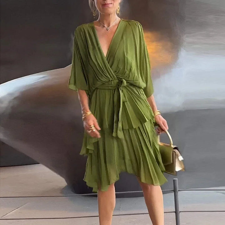 Olivgrünes Midikleid mit V-Ausschnitt, Wickeloptik, Taillenband und gestuftem Rock in fließendem Design.
