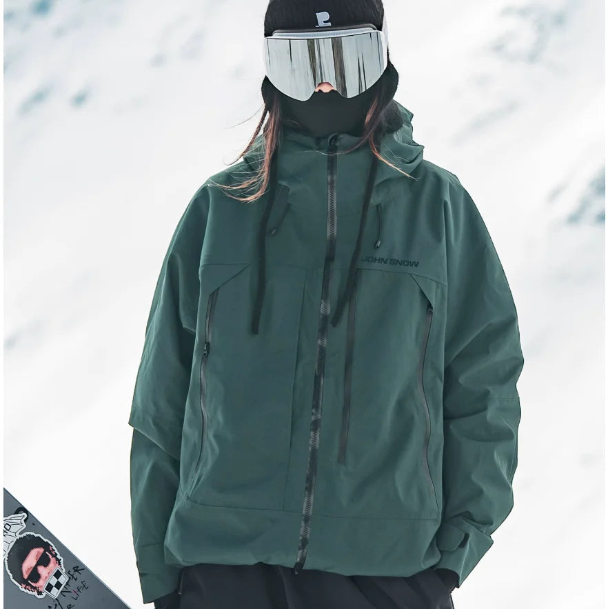 Dunkelgrüne, wasserdichte Melina Damen-Skijacke mit Kapuze, Reißverschlusstaschen und lockerem Schnitt im Schnee.