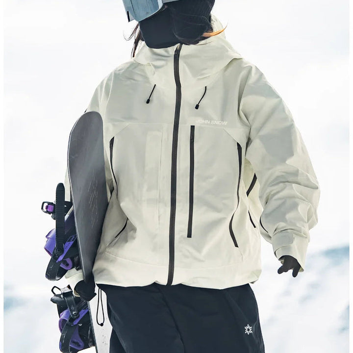 Weiße, wasserdichte Melina Damen-Skijacke mit Kapuze, Reißverschlusstaschen und lockerem Schnitt beim Snowboarden.