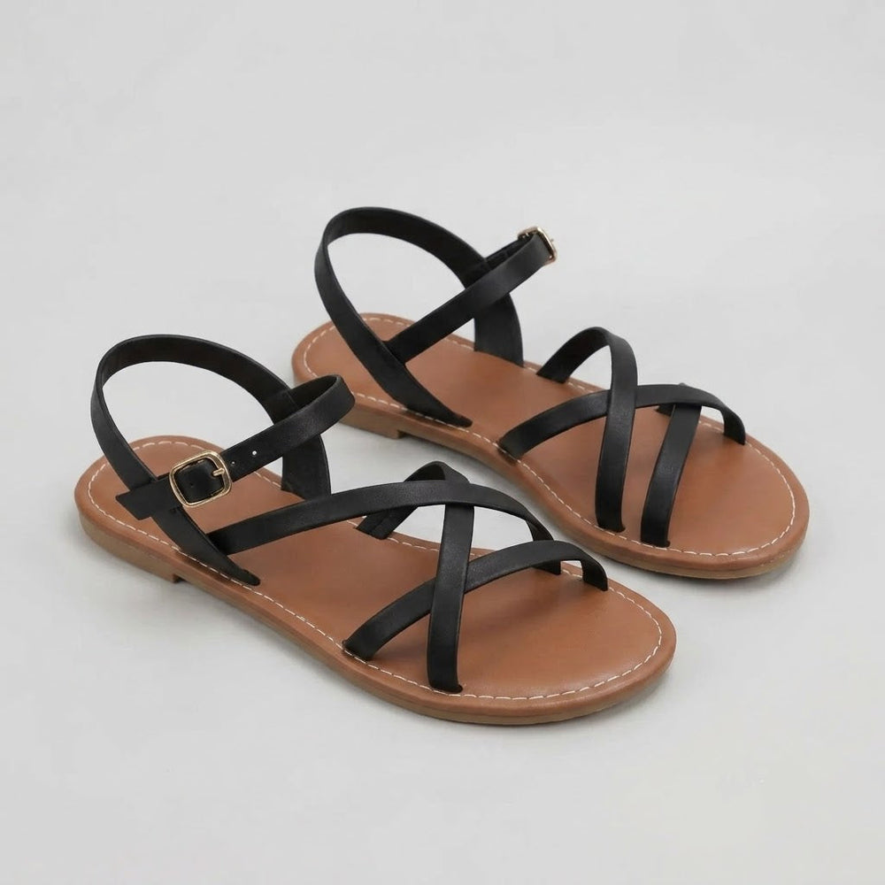 Schwarze Mia Damen Crisscross Flache Sandalen mit schlanken Überkreuzriemen, offener Zehenpartie und verstellbarem Knöchelriemen.