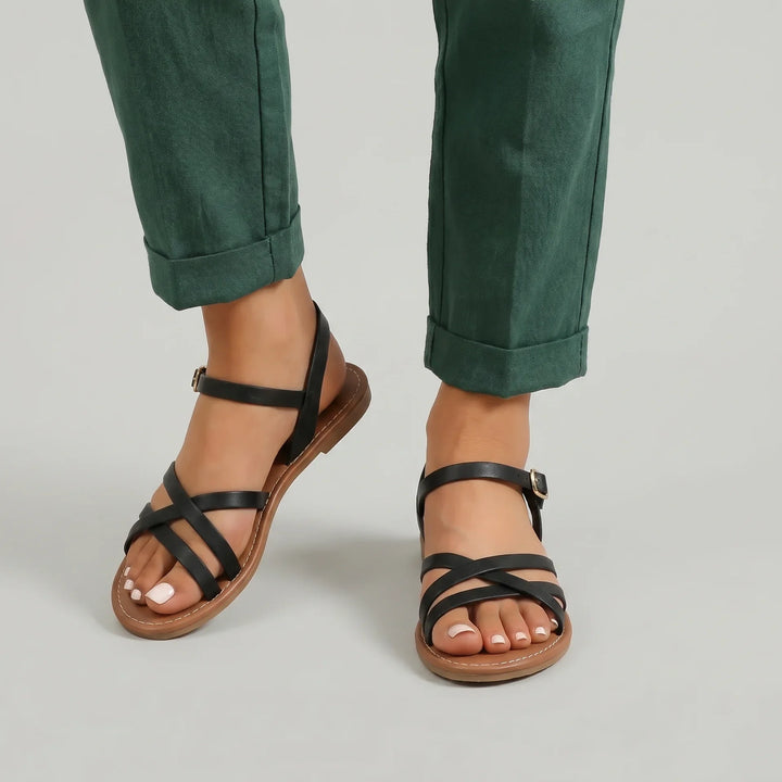 Mia Damen Crisscross Flache Sandalen in Schwarz mit schlanken Überkreuzriemen, offener Zehenpartie und verstellbarem Knöchelriemen.
