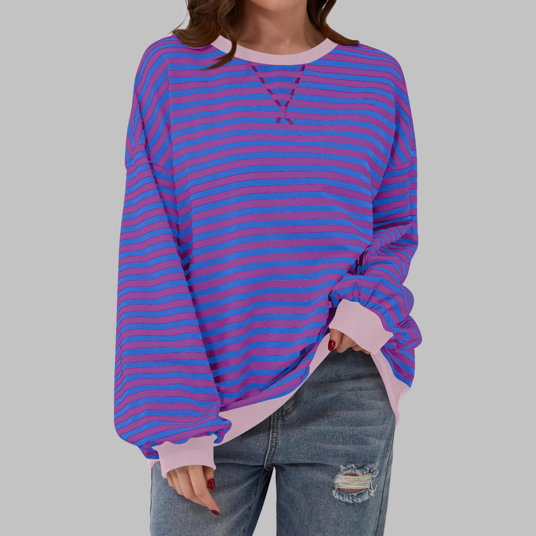 Oversized Damen-Sweatshirt mit blau-violettem Streifenmuster, Rundhalsausschnitt und hellrosa Bündchen.