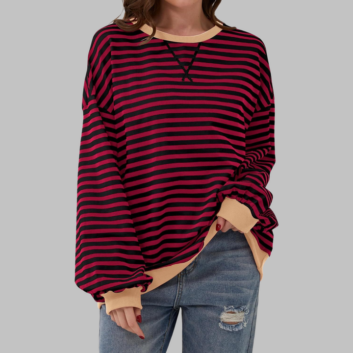 Oversized Damen-Sweatshirt mit rot-schwarzem Streifenmuster, Rundhalsausschnitt und beigen Bündchen in lässiger Passform.