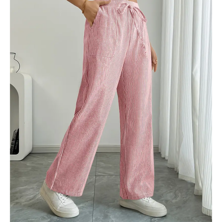 Weite Leinenhose mit rot-weißem Streifenmuster, Kordelzug am Bund und praktischen Seitentaschen.