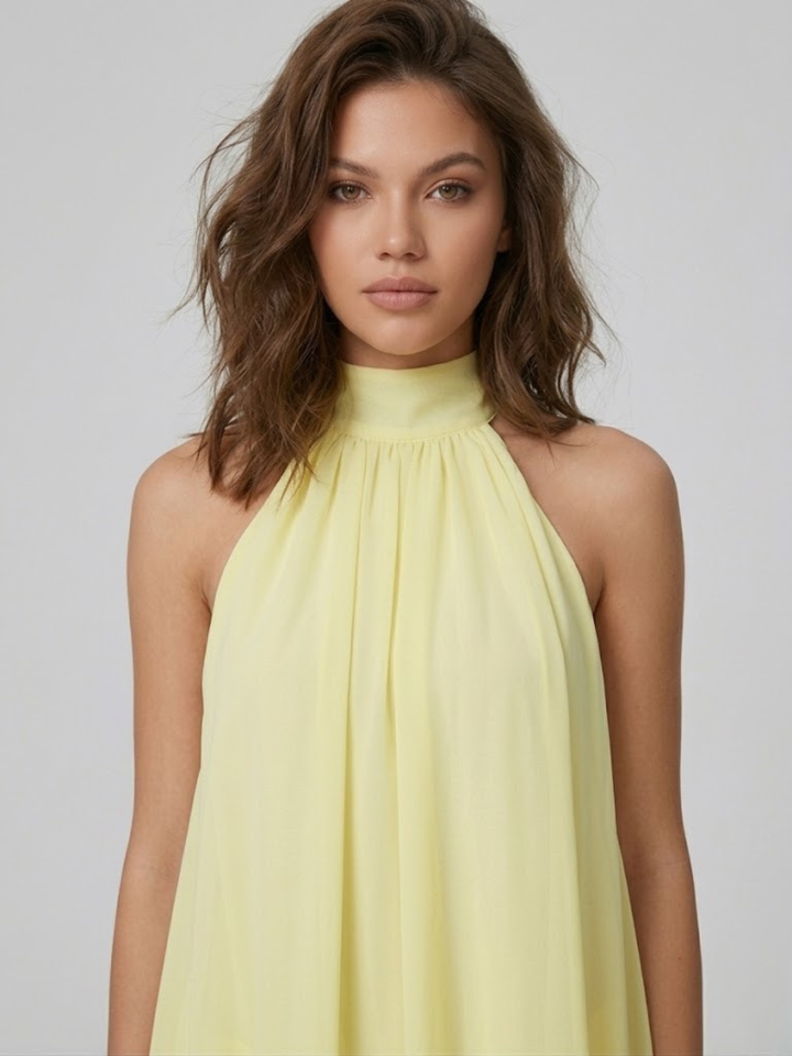 Hellgelbes Mira Minikleid mit elegantem Neckholder-Ausschnitt aus leichtem, fließendem Stoff.