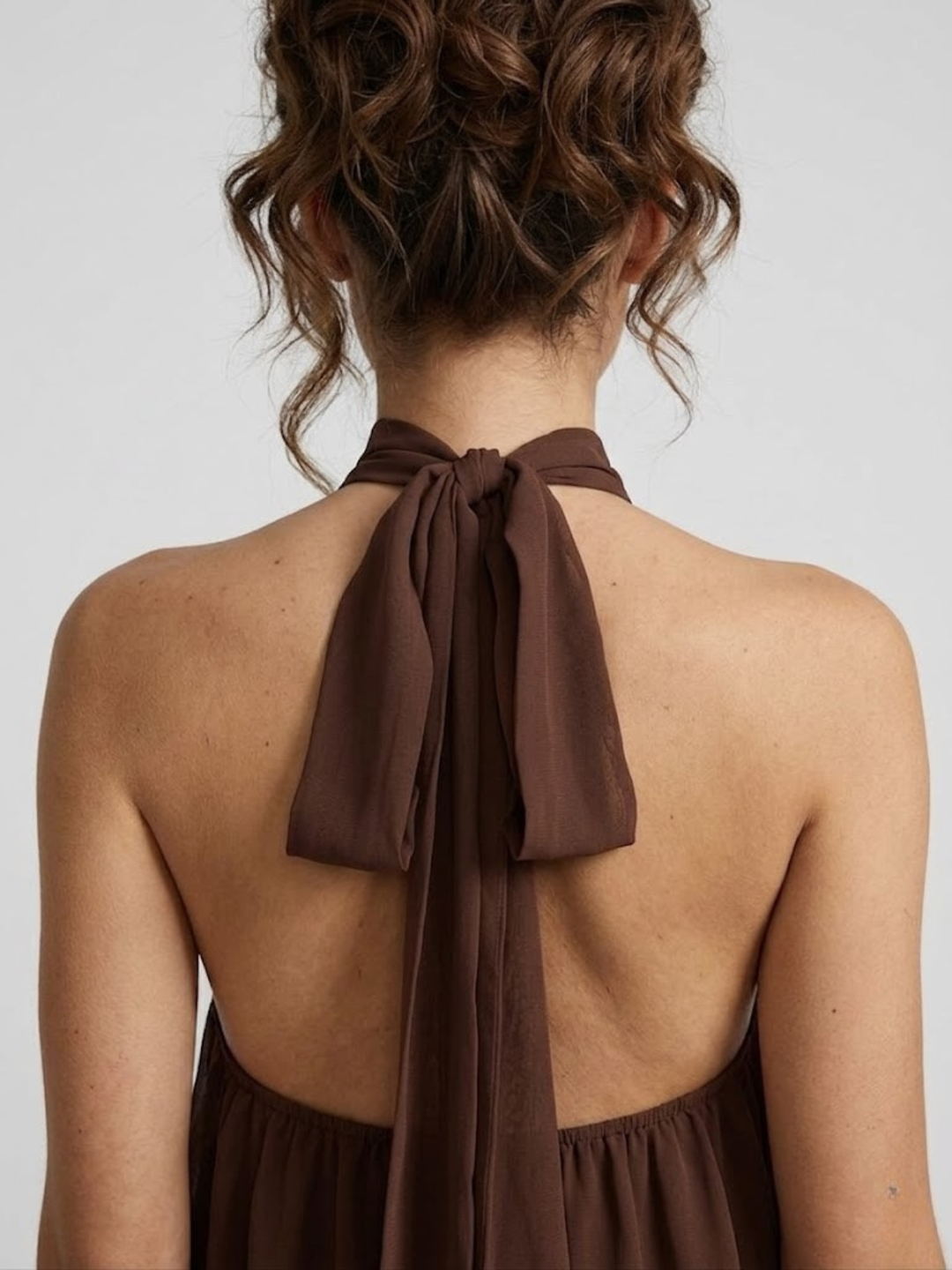 Dunkelbraunes Mira Minikleid mit elegantem Neckholder-Ausschnitt und offenem Rücken zum Binden.