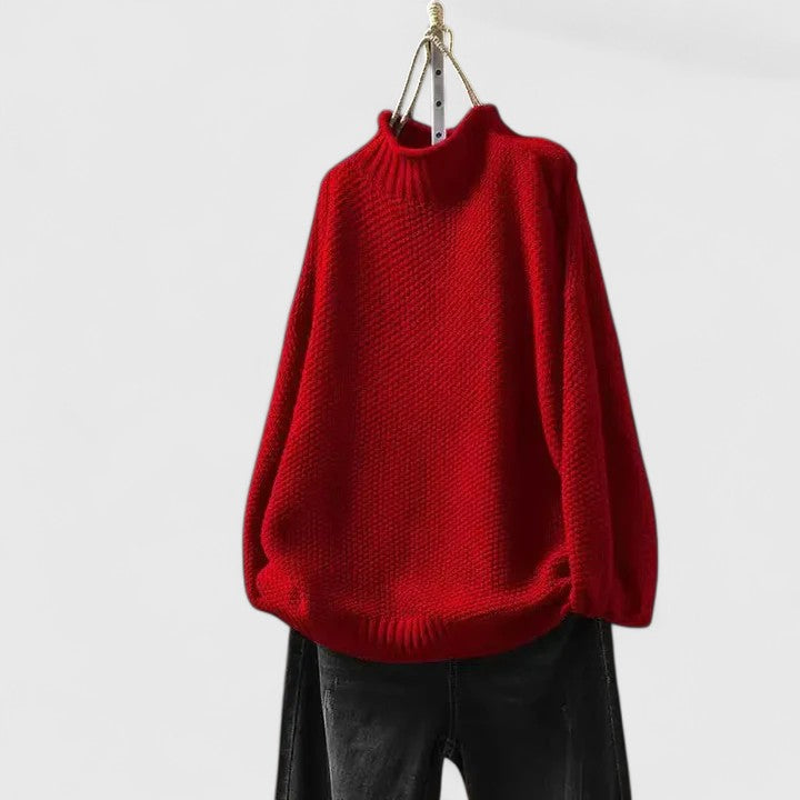 Roter Damen-Strickpullover mit Stehkragen, strukturiertem Strickmuster und entspannter Passform auf einem Kleiderbügel.