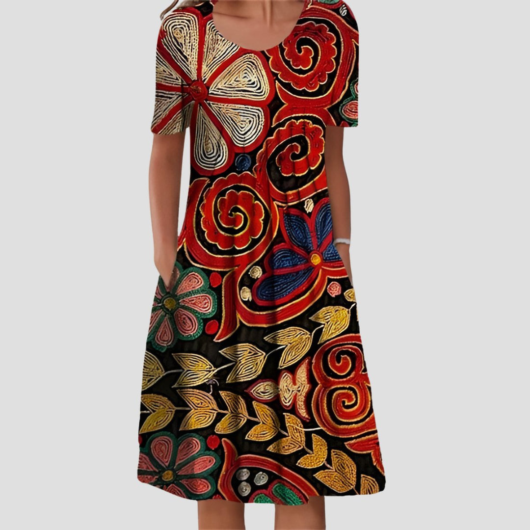 Miriam Midikleid mit buntem Blumenmuster, A-Linien-Schnitt, Rundhalsausschnitt, kurzen Ärmeln und praktischen Seitentaschen.