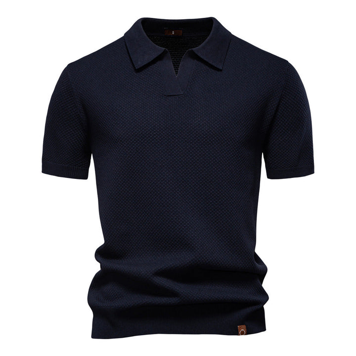 Dunkelblaues Herren-Poloshirt mit feiner Struktur, offenem Kragen und gerippten Bündchen in moderner Passform.