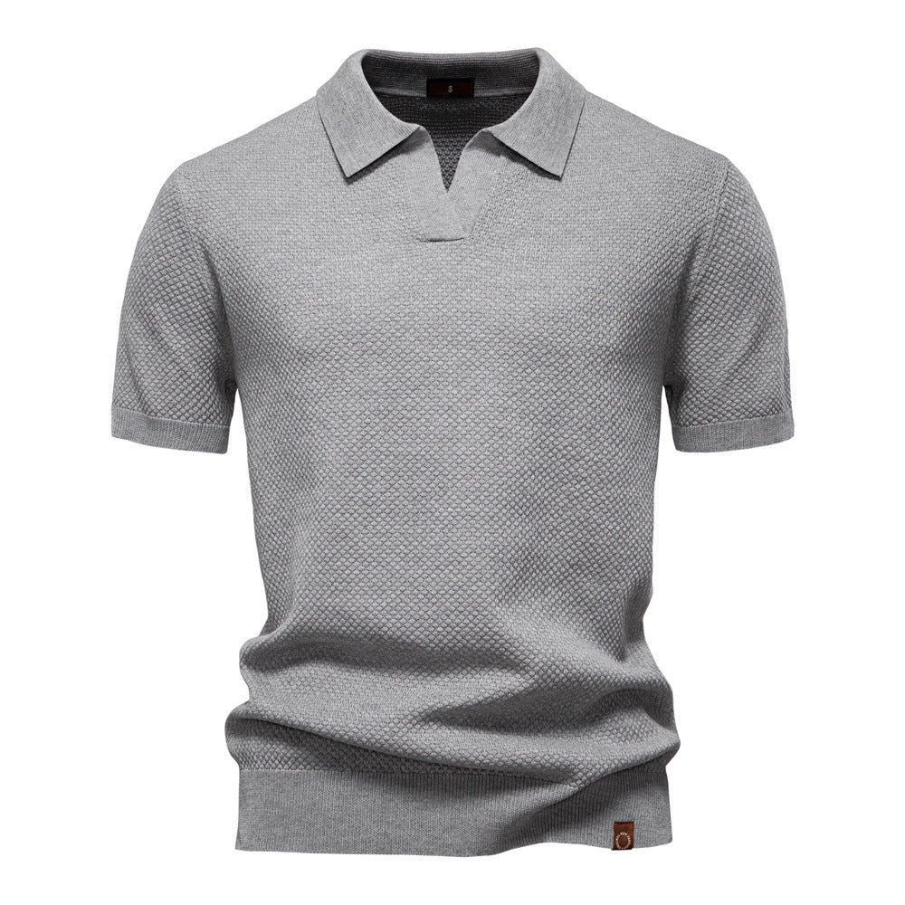Graues Herren-Poloshirt mit feiner Struktur, offenem Kragen, kurzen Ärmeln und moderner Passform.