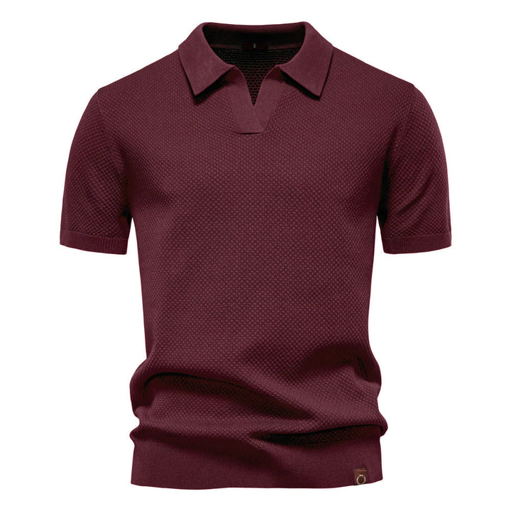 Dunkelrotes Herren-Poloshirt mit feiner Struktur, offenem Kragen und gerippten Bündchen in moderner Passform.
