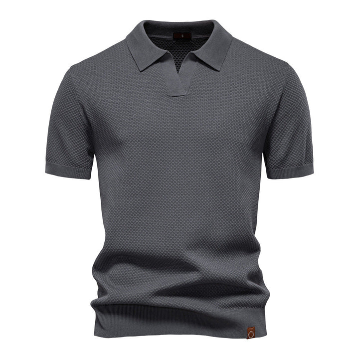 Dunkelgraues Herren-Poloshirt mit feiner Struktur, offenem Kragen und gerippten Bündchen in moderner Passform.