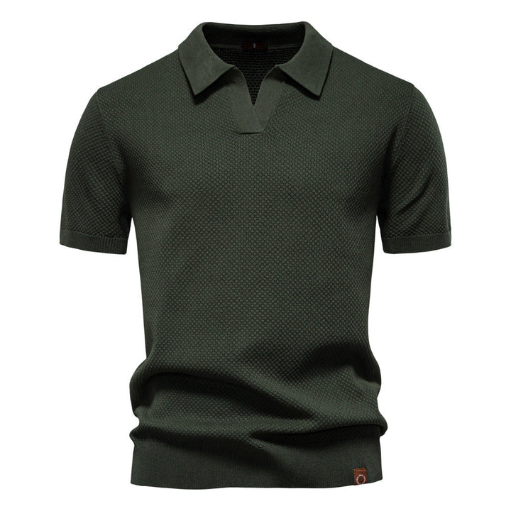 Dunkelgrünes Herren-Poloshirt mit feiner Struktur, offenem Kragen, kurzen Ärmeln und moderner Passform.