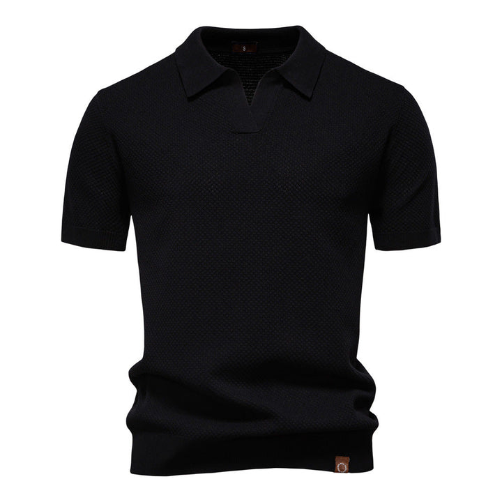 Schwarzes Herren-Poloshirt mit feiner Struktur, offenem Kragen, kurzen Ärmeln und moderner Passform.