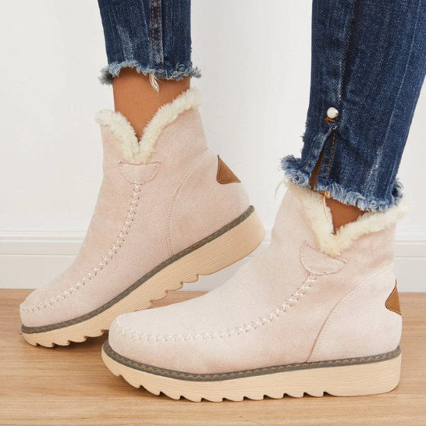 Beigefarbene Damen-Stiefeletten in Wildlederoptik mit flauschigem Kunstfell-Futter, Mokassin-Ziernaht und gerippter Laufsohle.