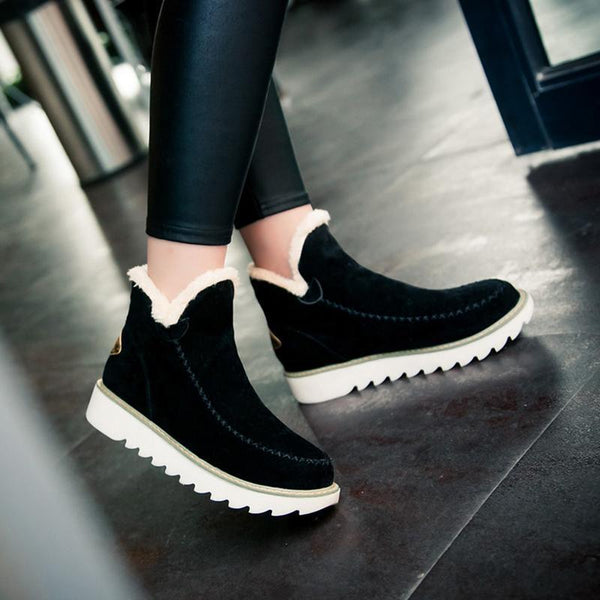 Schwarze Damen-Winterstiefeletten in Wildlederoptik mit flauschigem Kunstfell-Futter und gerippter weißer Laufsohle.