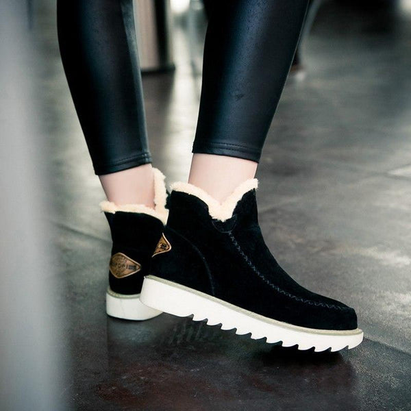 Schwarze Damen-Winterstiefeletten in Wildlederoptik mit flauschigem Kunstfell, Mokassin-Ziernaht und gerippter Laufsohle.