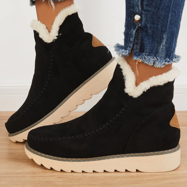 Schwarze Damen-Winterstiefeletten in Wildlederoptik mit flauschigem Kunstfell, Mokassin-Ziernaht und gerippter Laufsohle.