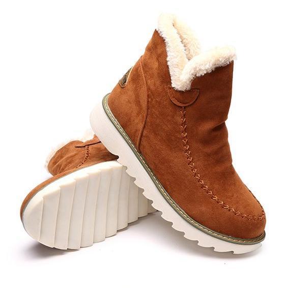 Braune Damen-Winterstiefeletten in Wildlederoptik mit flauschigem Kunstfellfutter und gerippter, weißer Laufsohle.