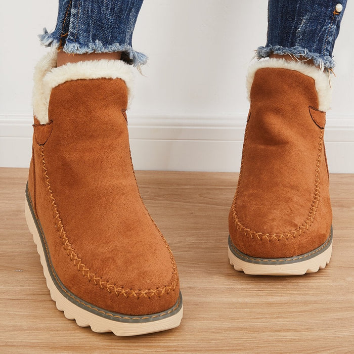Braune Damen-Winterstiefeletten in Wildlederoptik mit flauschigem Kunstfell-Kragen und markanter Mokassin-Ziernaht.