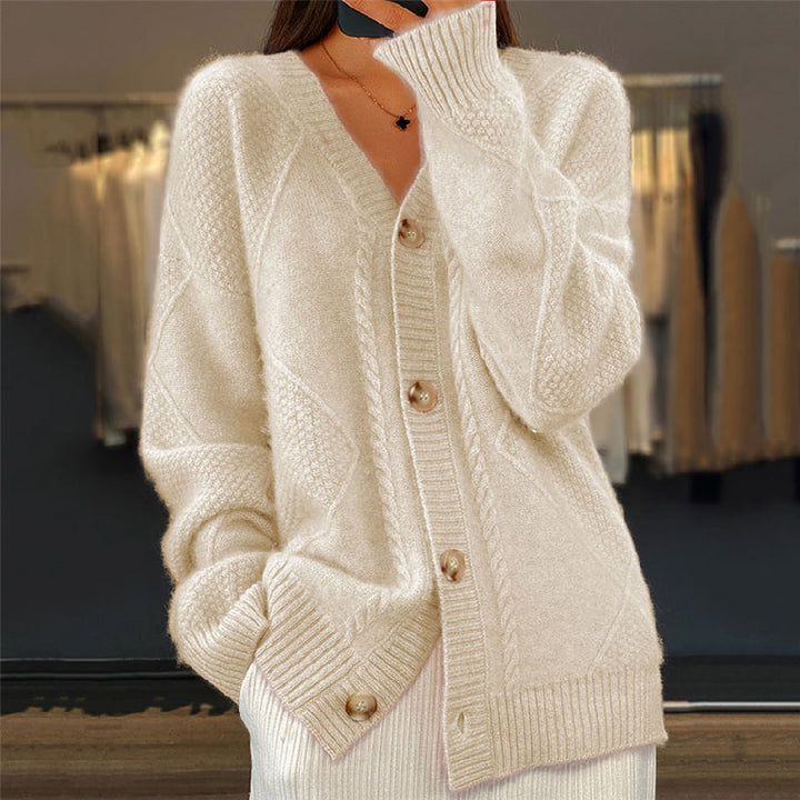 Beigefarbene Strickjacke Nina mit Zopfmuster, V-Ausschnitt und durchgehender Knopfleiste aus weichem Strickmaterial.