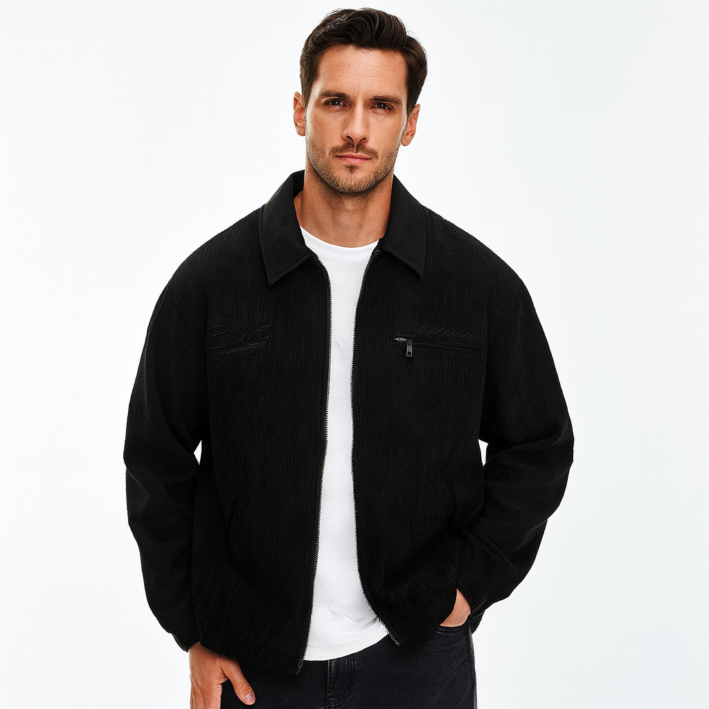 Schwarze Herren-Cordjacke mit Reißverschluss, Umlegekragen und Brusttasche, getragen über einem weißen T-Shirt.