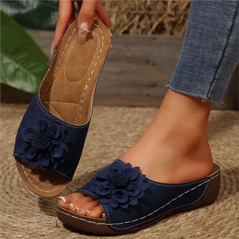 Blaue Nora Damen Keilsandaletten mit dekorativer Blume und braunem Fußbett.